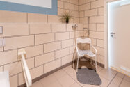 gefliestes Bad mit Waschbecken Toilette und Sitzdusche