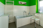 helles freundliches Badezimmer farbe grün weiss mit Wanne und Duschmöglichkeit