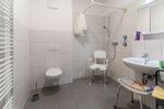 barierrefreies Badezimmer mit Waschbecken Toilette und Sitzdusche