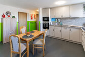 helle Küche mit Küchenzeile mit Esstisch