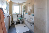 barierrefreies Badezimmer mit Waschbecken Toilette und Sitzdusche